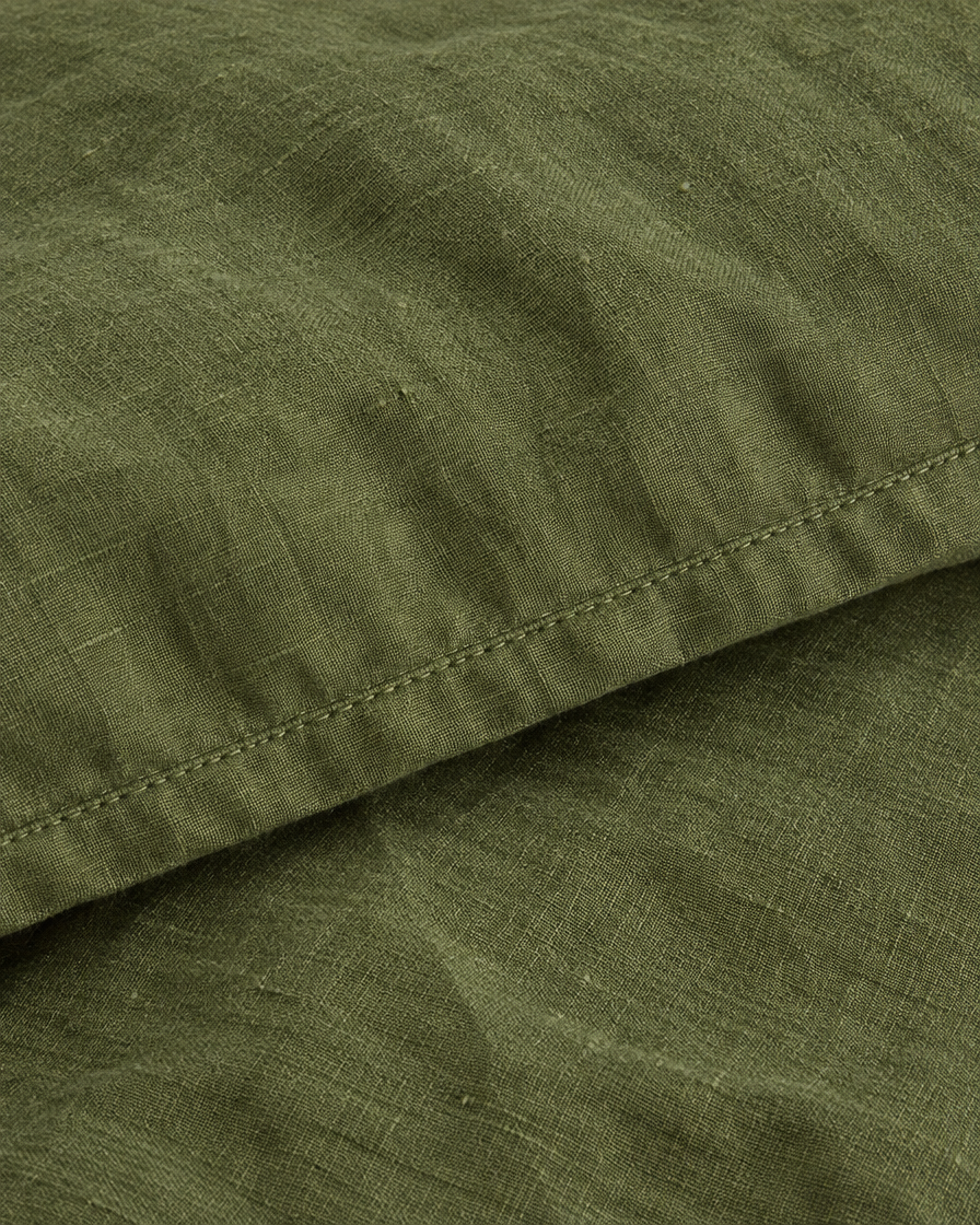 Close-up of stitched hem of the duvet cover in Moss Green Linen