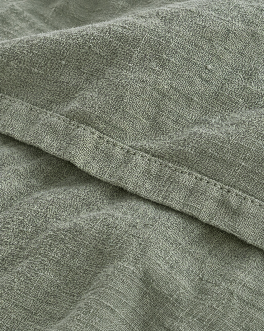 Close-up of stitched hem of the duvet cover in Sage Linen