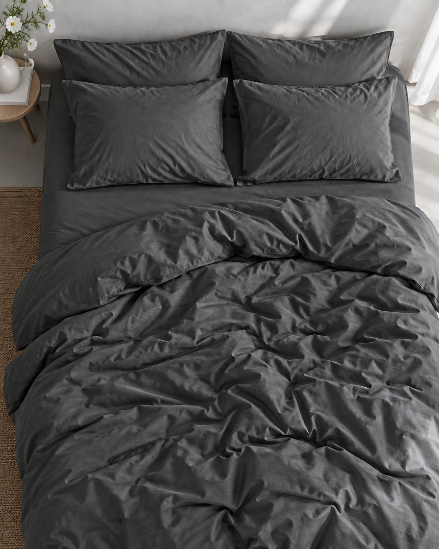 Charcoal Grey silky cotton bedding from above, the duvet softly rumpled over the matching fitted sheet and pillows