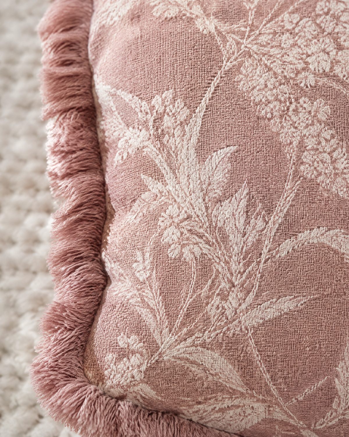 Close-up of dusty rose floral jacquard with fringed edge