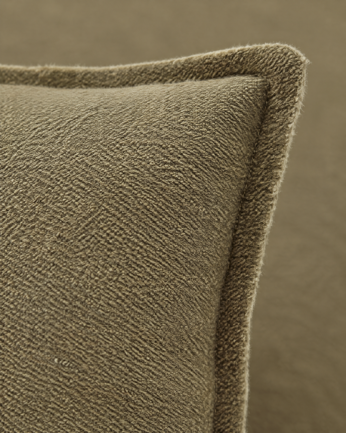 Macro close-up of the olive khaki slub jacquard, a fine heathered twill texture and the flange edge