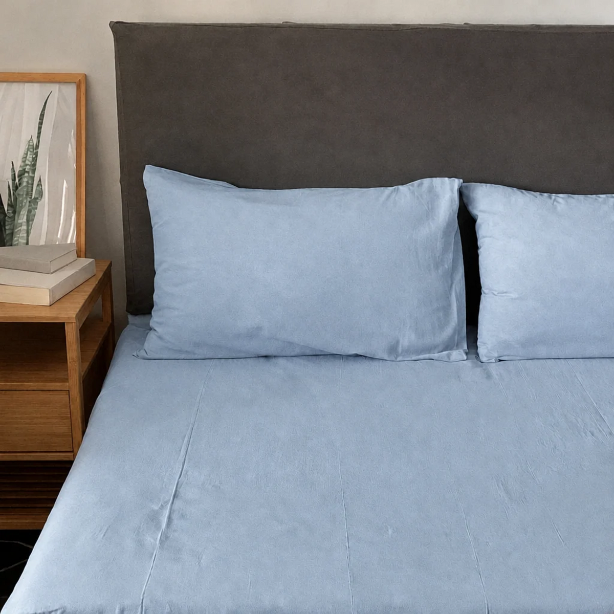 Baby Blue plain cotton fitted sheet and pillowcases in soft powder blue against a grey headboard