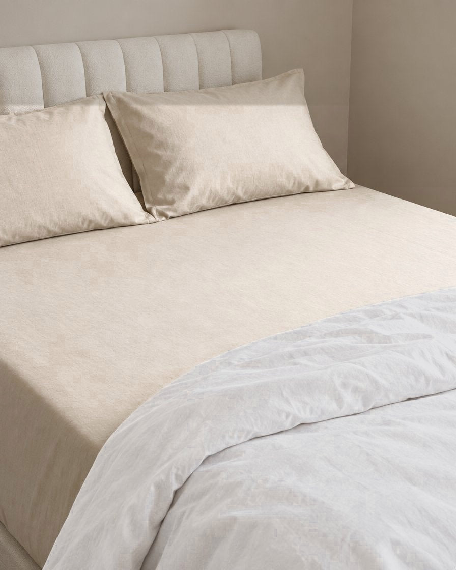 Cream plain cotton fitted sheet, a boucle armchair in the corner