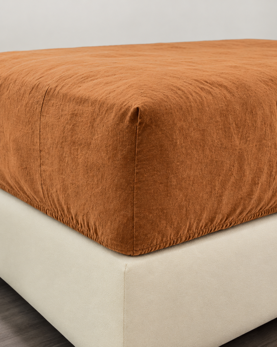 Terracotta French linen fitted sheet on a mattress corner