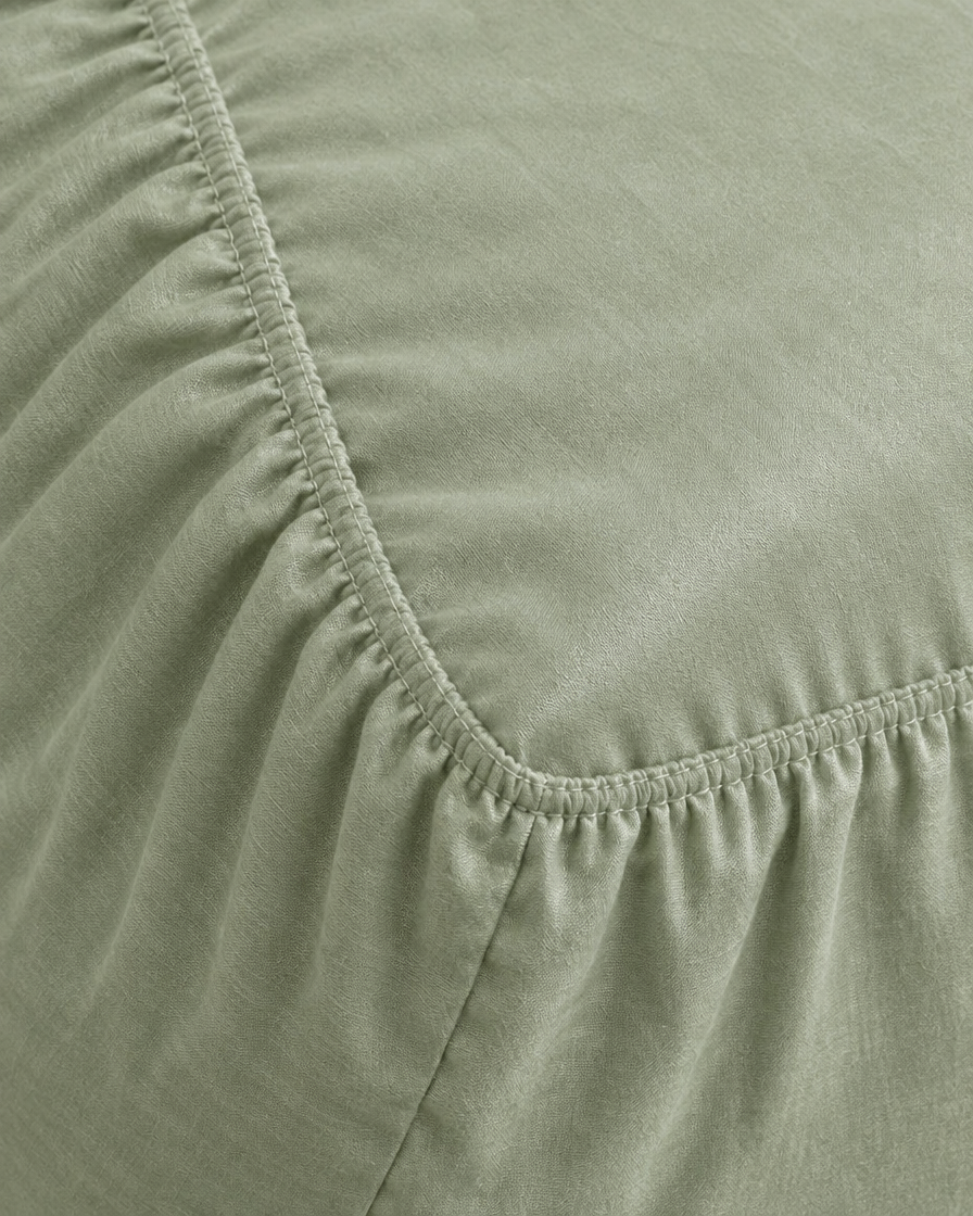 Close-up of elasticated corner and stitched edge of the fitted sheet in Mint Green Silky Cotton