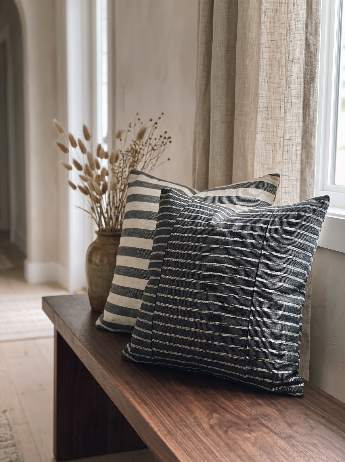 Charcoal Stripe Jacquard Linen Viscose Cushion Covers on a walnut bench