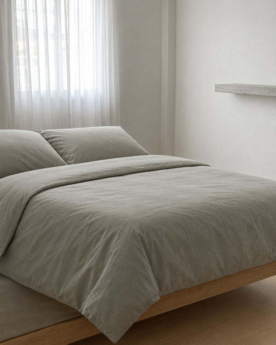 Mint Grey plain cotton pillowcases, a boucle armchair in the corner