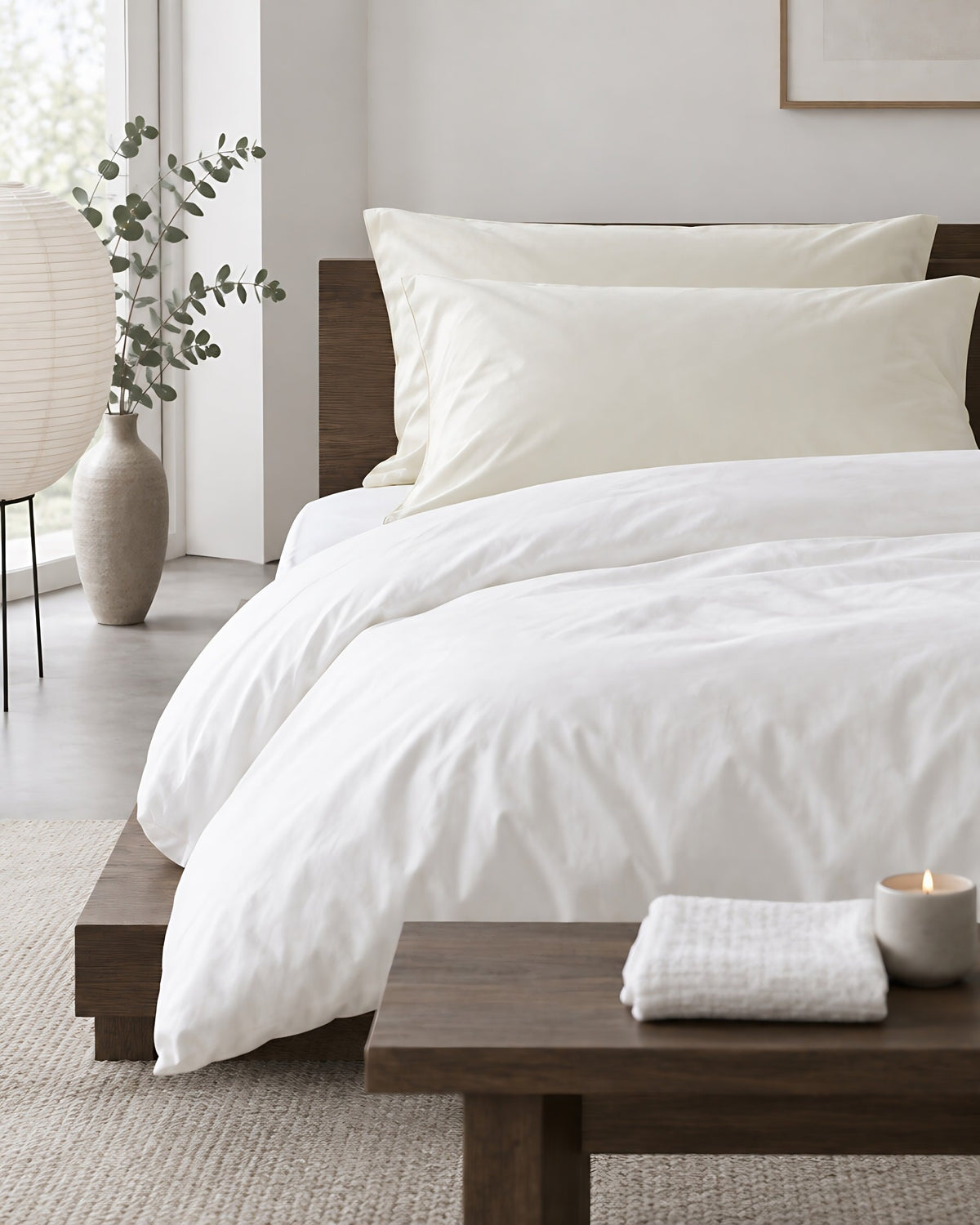 Vanilla silky cotton pillowcases in a calm Japandi bedroom on a low dark-oak bed