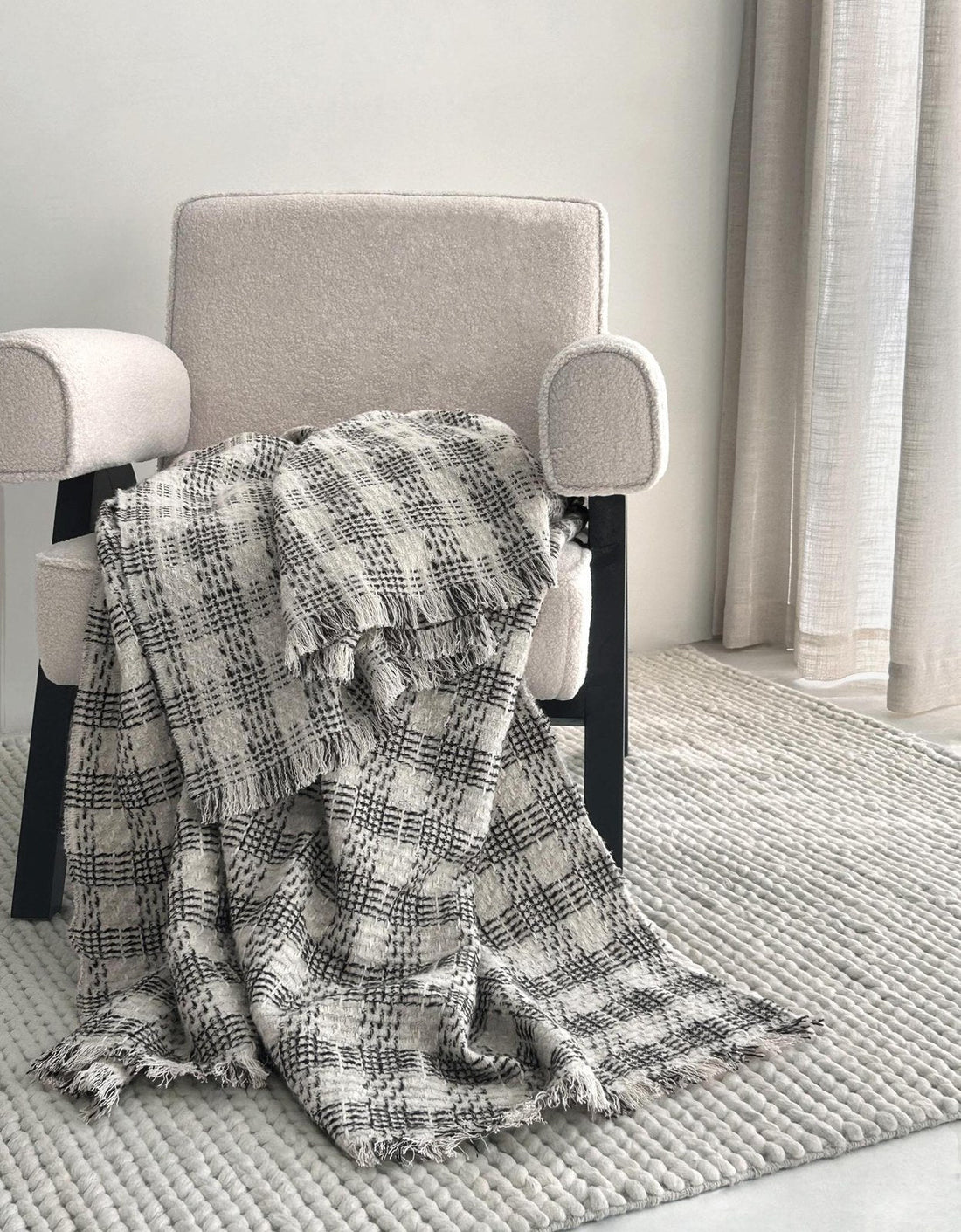 Black and white check wool mohair throw over a cream armchair