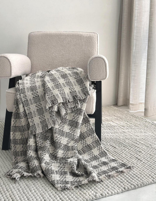 Black and white check wool mohair throw over a cream armchair