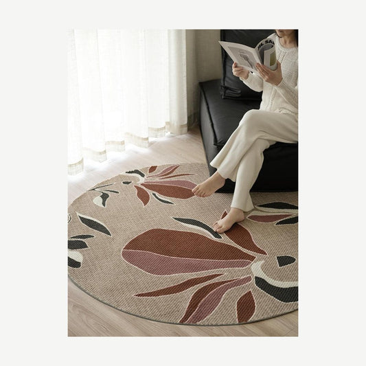 Woman reading on a round rug with a soft magnolia flower print