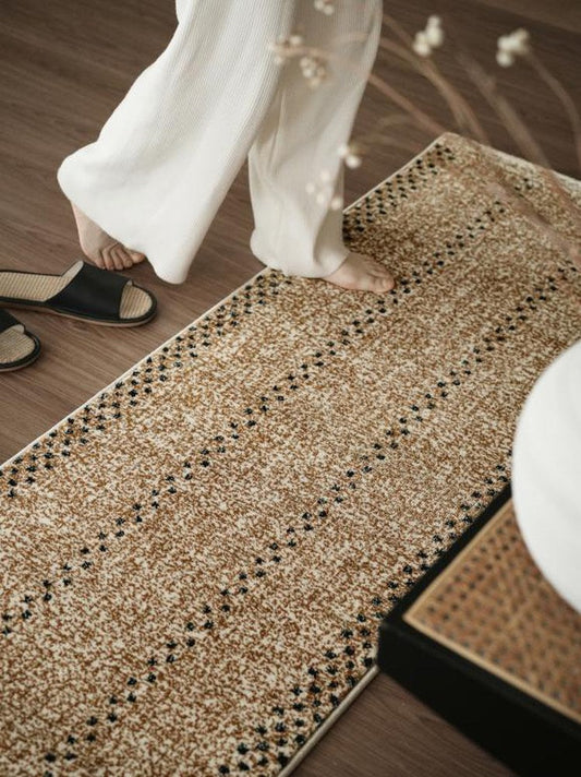 Tan flatwoven runner rug with black dot bands laid the length of a hallway