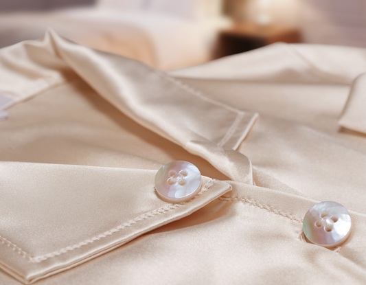 Close-up of a cream silk placket with mother-of-pearl buttons, where the momme weight shows