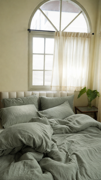 Mint Green cloud cotton bedding set in soft grey-sage on a bed beneath an arched window