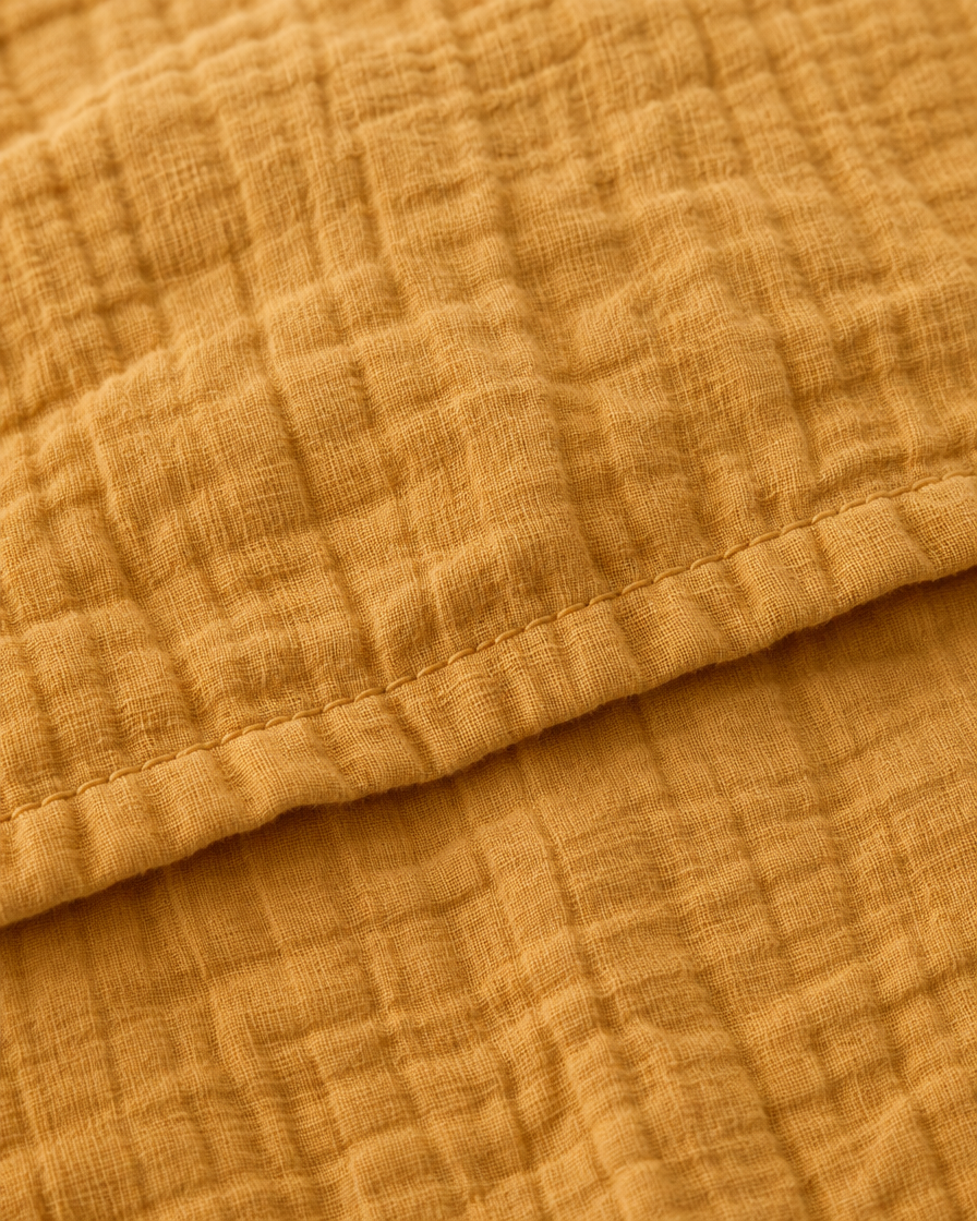 Close-up of stitched hem of the duvet cover in Mustard Cloud Cotton