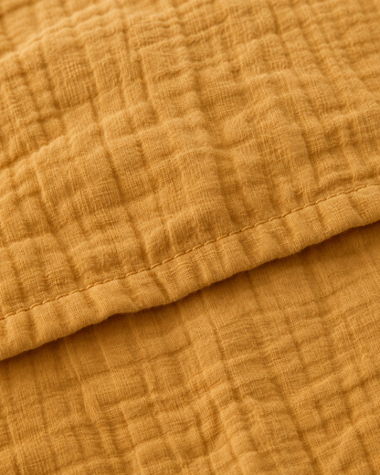 Close-up of stitched hem of the duvet cover in Mustard Cloud Cotton