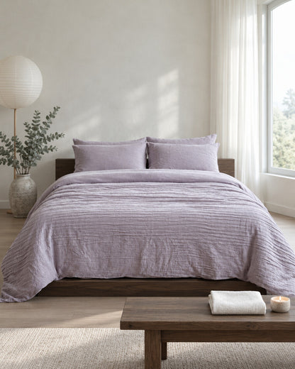 Lilac cloud cotton bedding set in a calm Japandi bedroom on a low dark-oak bed