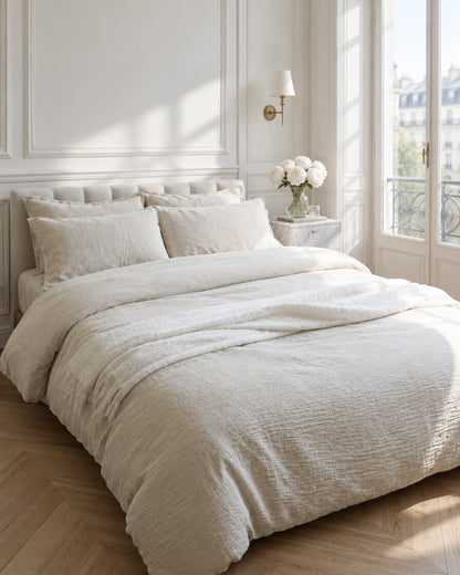Cream cloud cotton bedding set in a Parisian bedroom with panelled walls and fresh peonies
