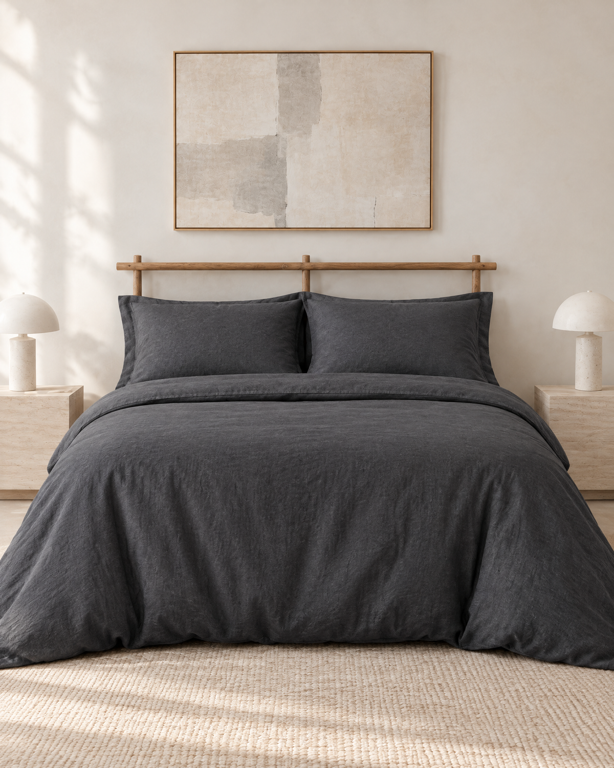Charcoal linen bedding set on a made bed in a bright bedroom