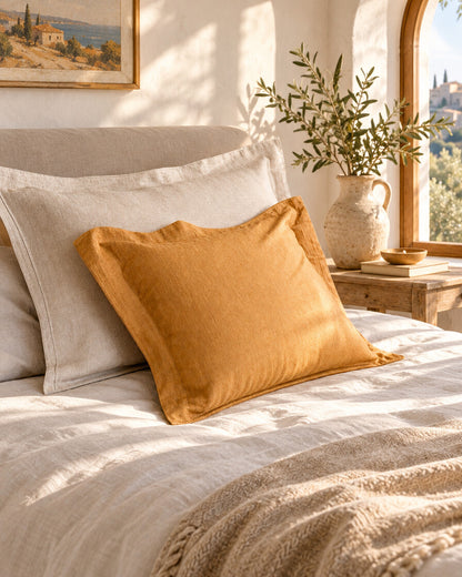Mustard and cream linen cushions, styled in a sun-washed Mediterranean bedroom