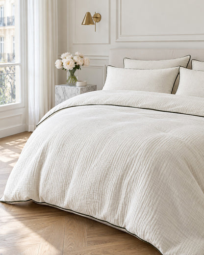 Cream piped cloud cotton bedding set in a Parisian bedroom with panelled walls and fresh peonies