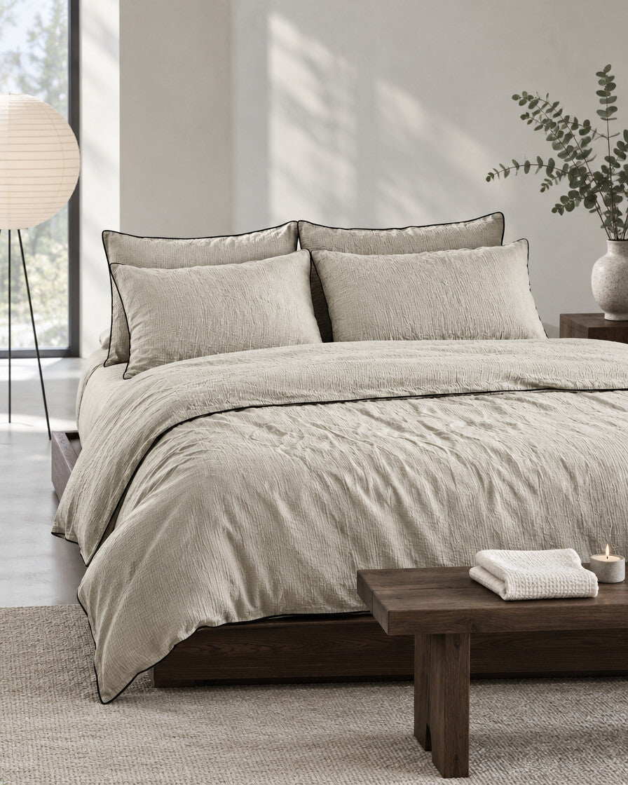 Taupe piped cloud cotton bedding set in a calm Japandi bedroom on a low dark-oak bed