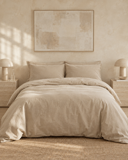 Beige Plain Cotton bedding set on a bed against a limewashed wall between travertine bedside tables and mushroom lamps