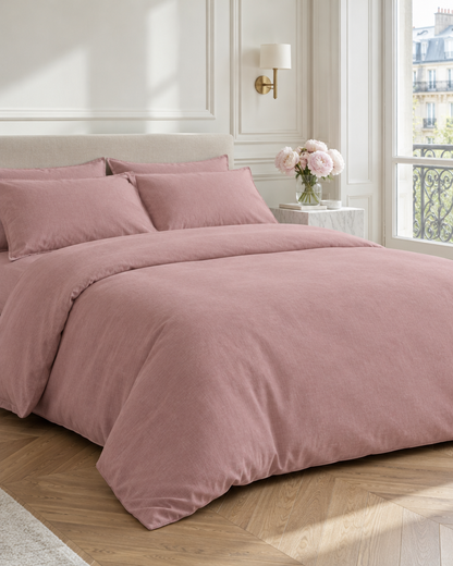 Dust Pink plain cotton bedding in a Parisian bedroom with herringbone oak floor, panelled walls and peonies on marble.