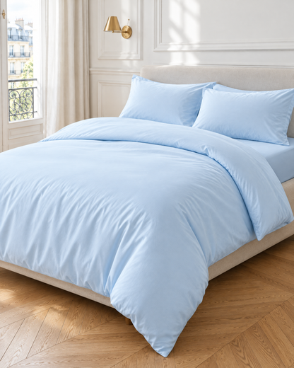 Baby Blue silky cotton sateen bedding set on a made bed in a bright bedroom