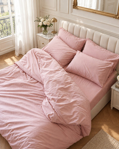Blush pink silky cotton bedding, styled in an elegant Parisian apartment bedroom