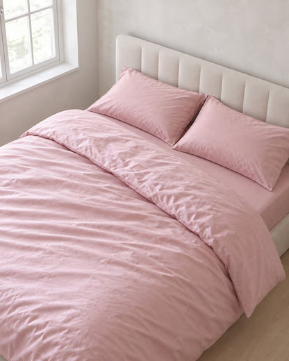 Rose Pink silky cotton bedding set, a boucle armchair in the corner