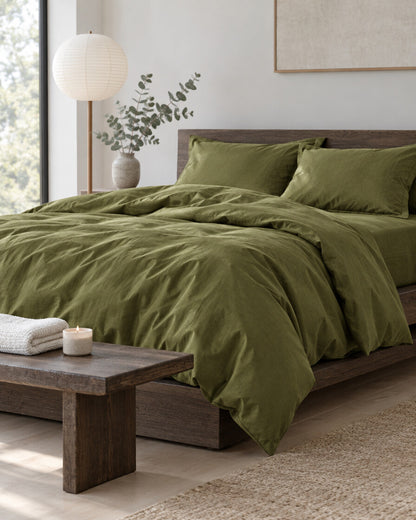 Olive green silky cotton bedding set in a calm Japandi bedroom on a low dark-oak bed, styled in calm neutrals