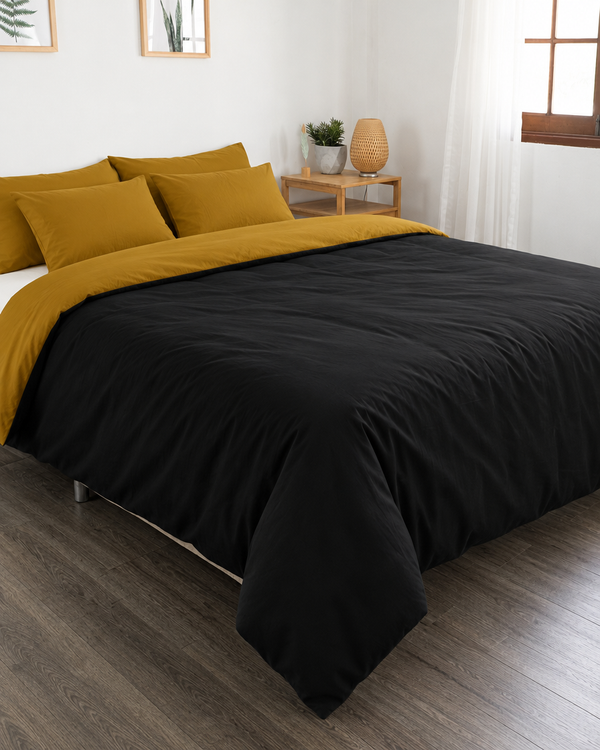 Black duvet cover with mustard reverse, off white fitted sheet and mustard pillowcases in Plain Cotton