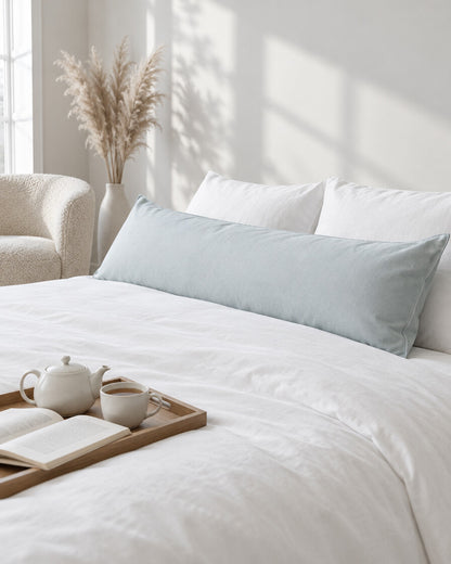 Pale blue and white plain cotton body pillowcase with a tea tray and open book, a boucle armchair in the corner