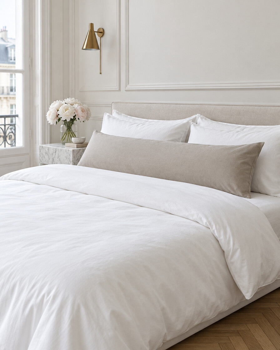 Taupe plain cotton body pillowcase in a Parisian bedroom with panelled walls and fresh peonies