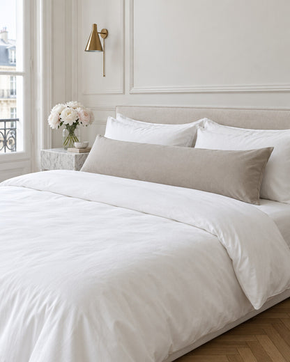 Taupe plain cotton body pillowcase in a Parisian bedroom with panelled walls and fresh peonies