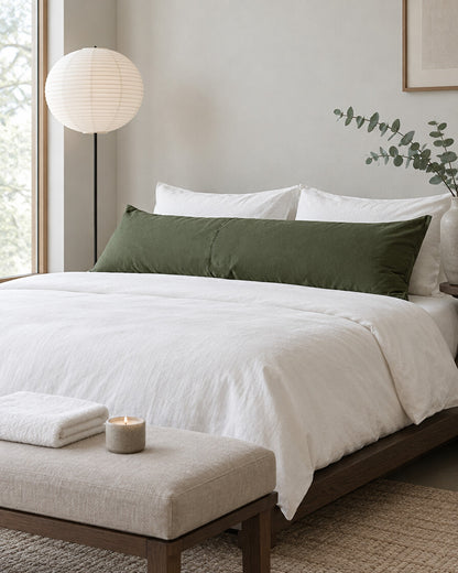 Olive green plain cotton body pillowcase in a calm Japandi bedroom on a low dark-oak bed