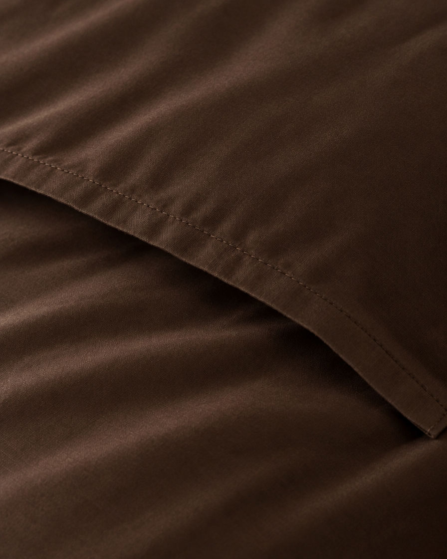 Macro of the stitched envelope end of a Chocolate silky cotton body pillowcase in chocolate brown sateen.