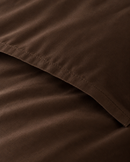 Macro of the stitched envelope end of a Chocolate silky cotton body pillowcase in chocolate brown sateen.