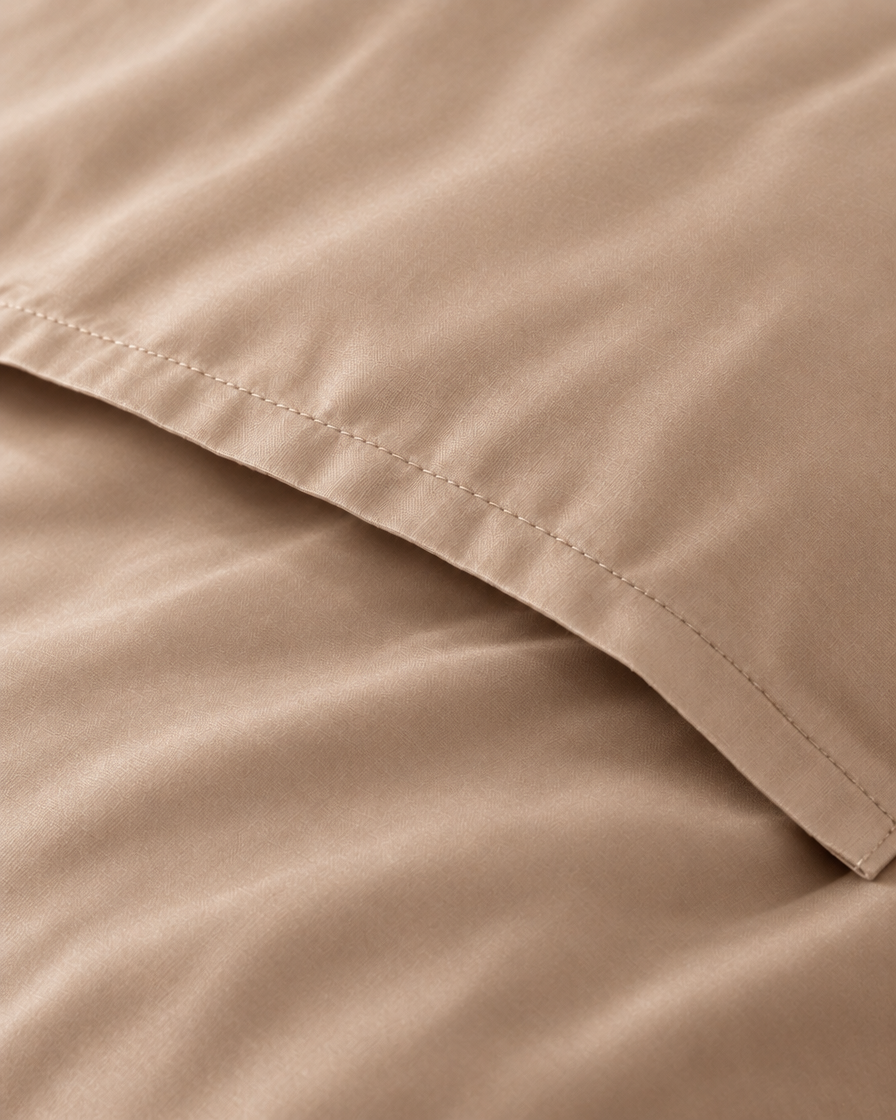 Macro of the stitched envelope end of a Light Beige silky cotton body pillowcase in beige sateen.