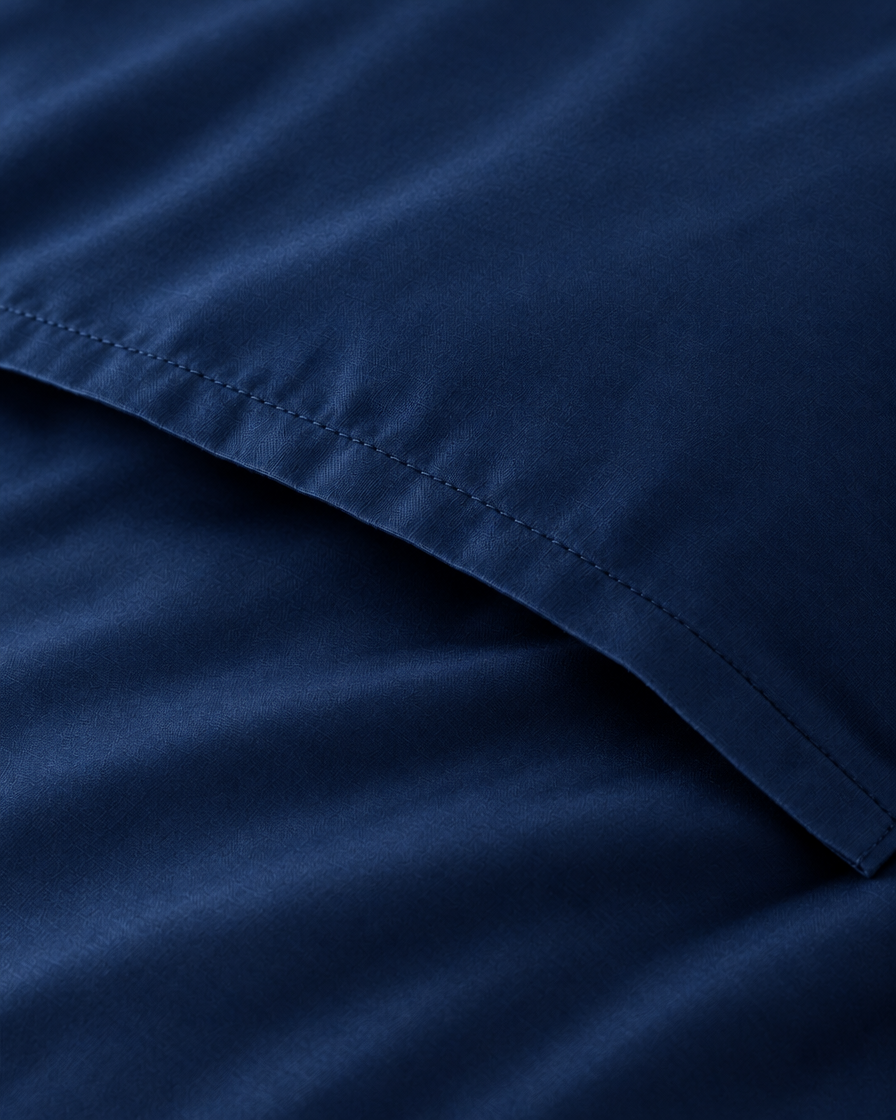 Macro of the stitched envelope end of a Marine Blue silky cotton body pillowcase in navy blue sateen.