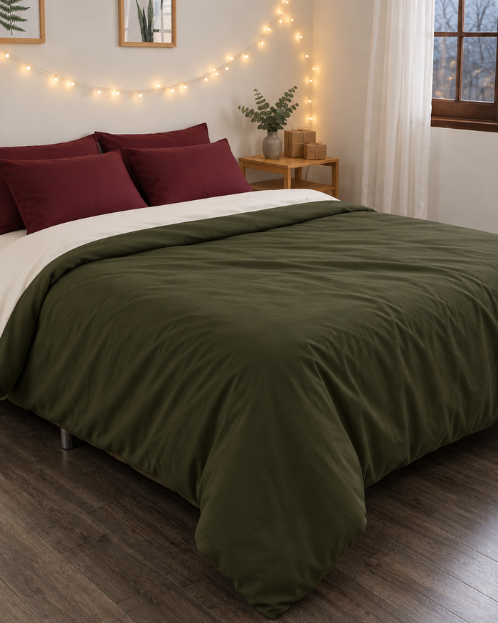 Forest green and burgundy cotton bed in a winter bedroom with evergreen branches