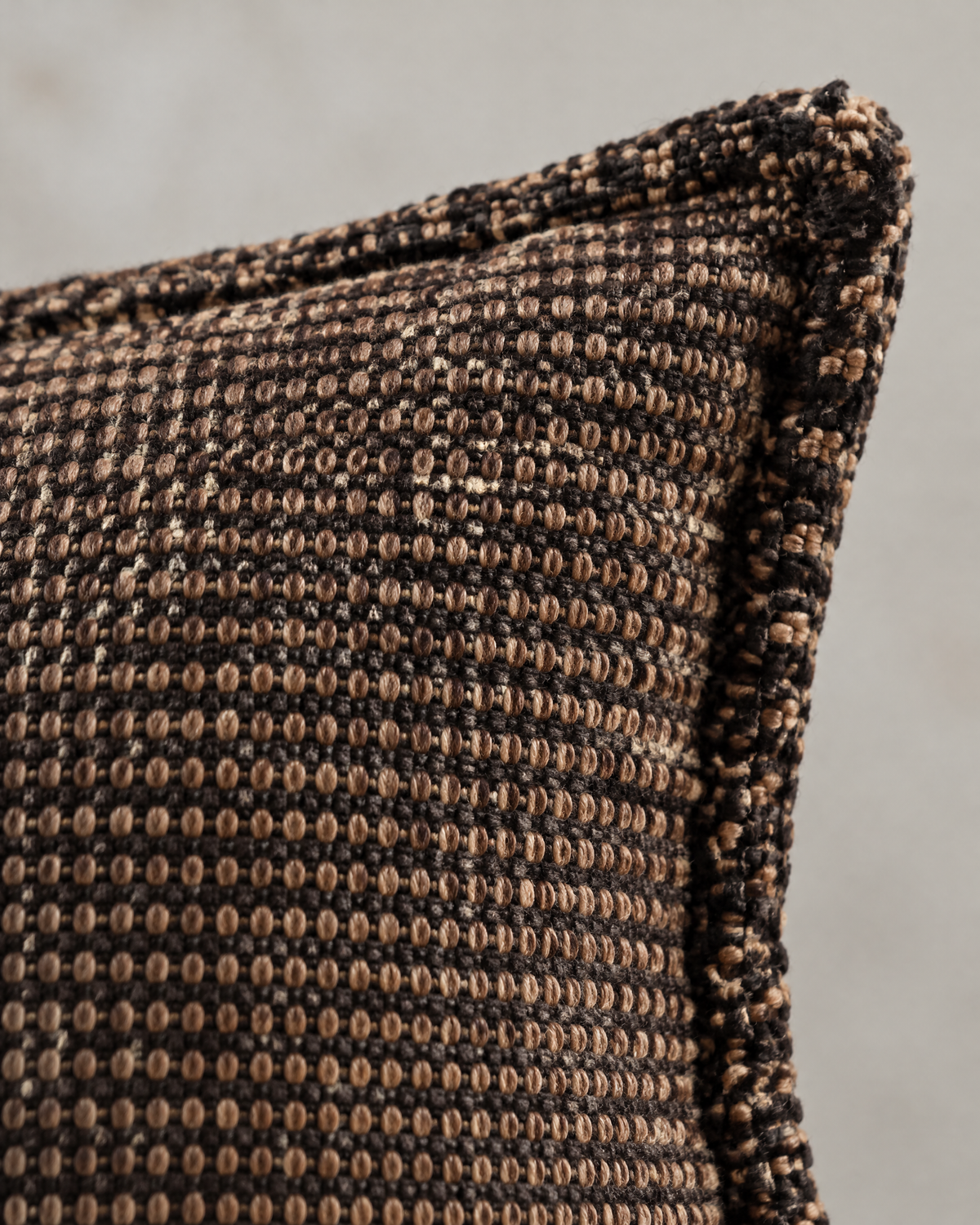 Macro close-up of the chocolate check jacquard, a tiny tan grid on dark brown with the fringed edge