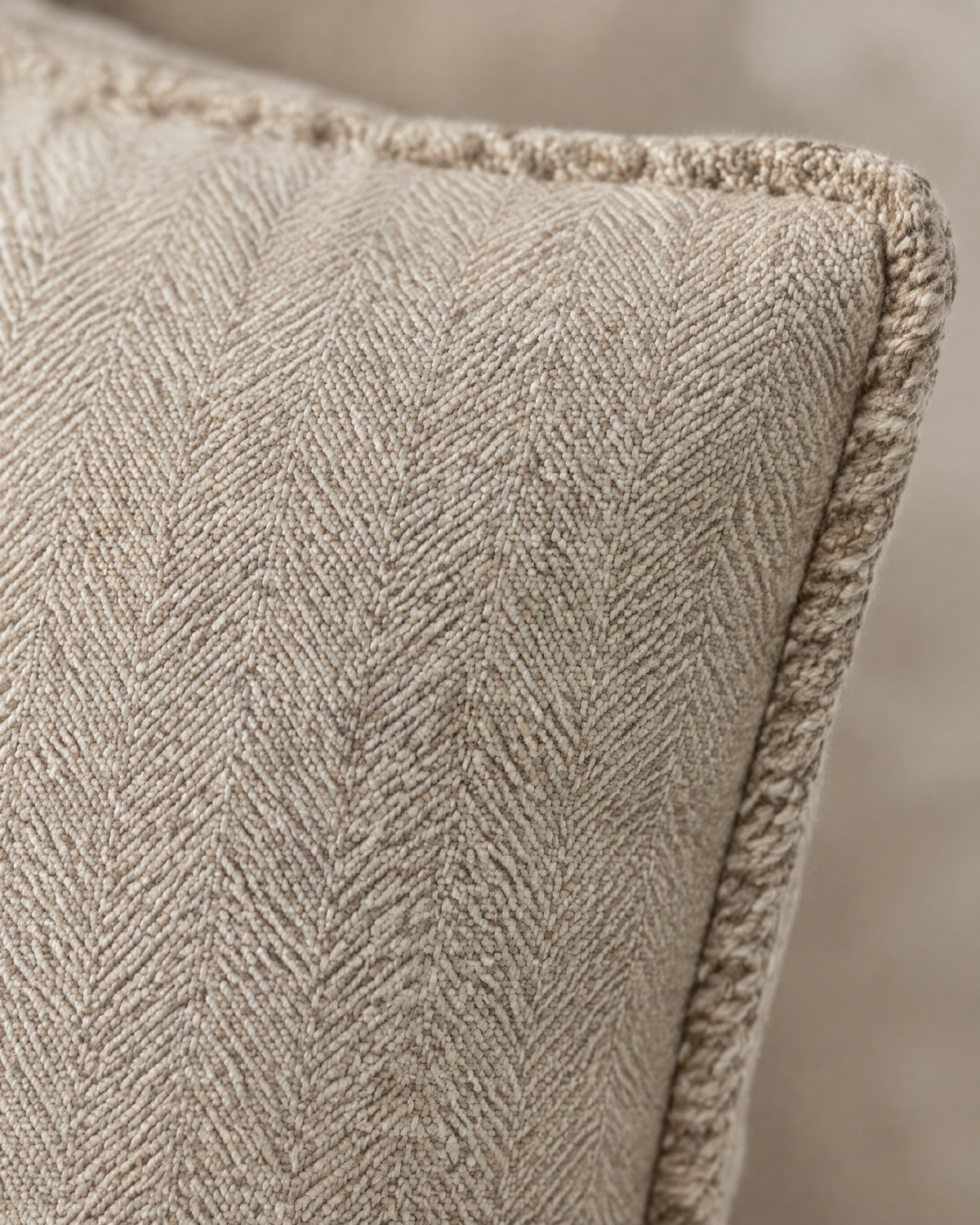 Macro close-up of the cocoa milk herringbone, a fine chevron weave in cotton linen with its dense whipstitched edge