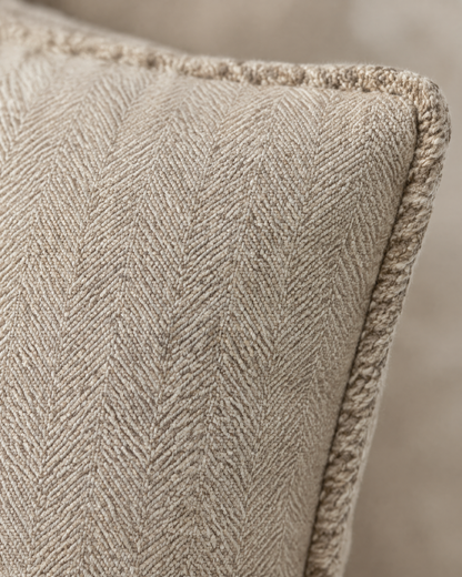 Macro close-up of the cocoa milk herringbone, a fine chevron weave in cotton linen with its dense whipstitched edge