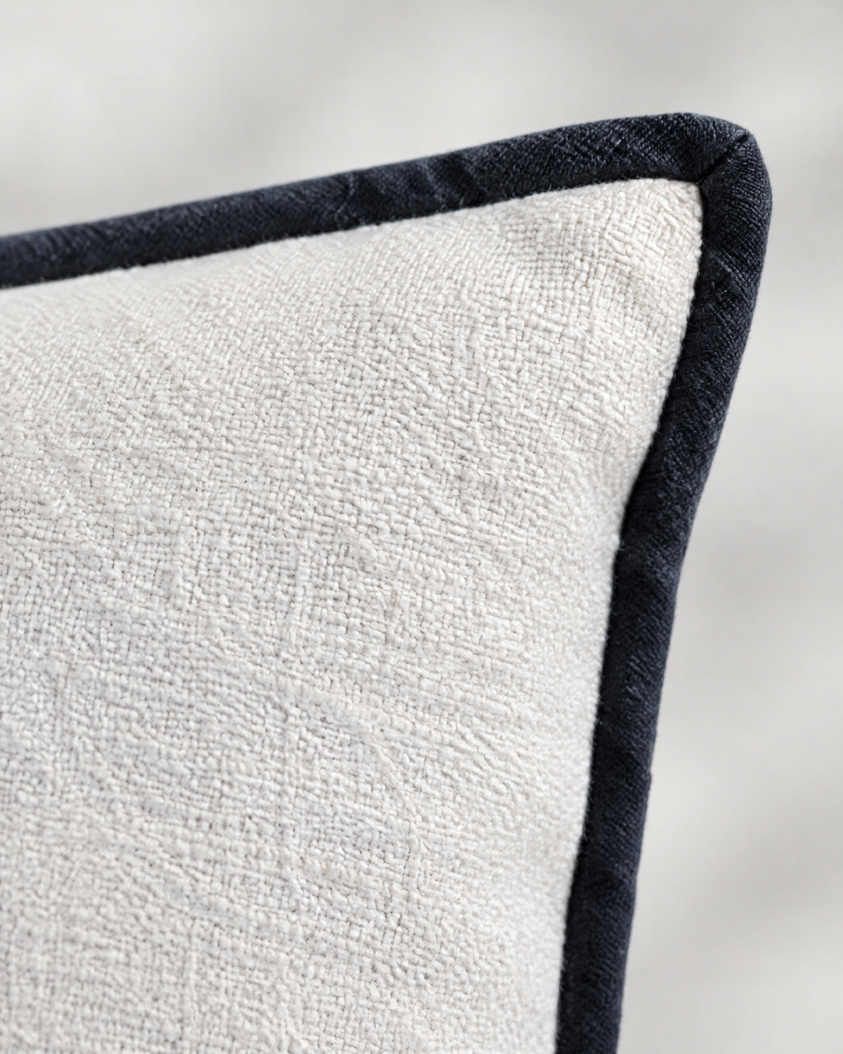 Close-up of ivory textured weave with black bound edge