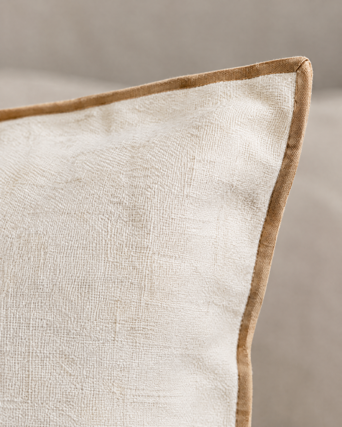 Close-up of white linen cotton with beige contrast edge