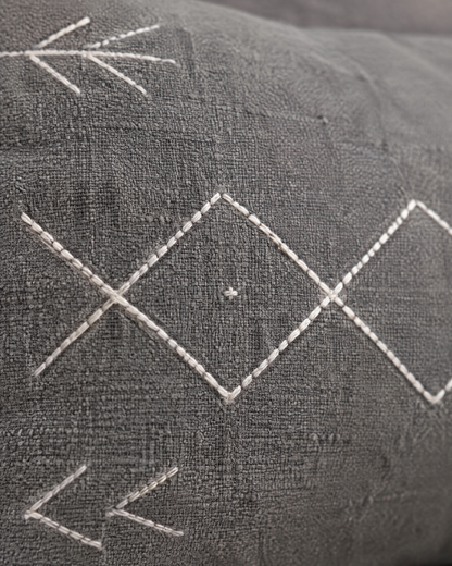 Close-up of ivory diamond and arrow embroidery on grey