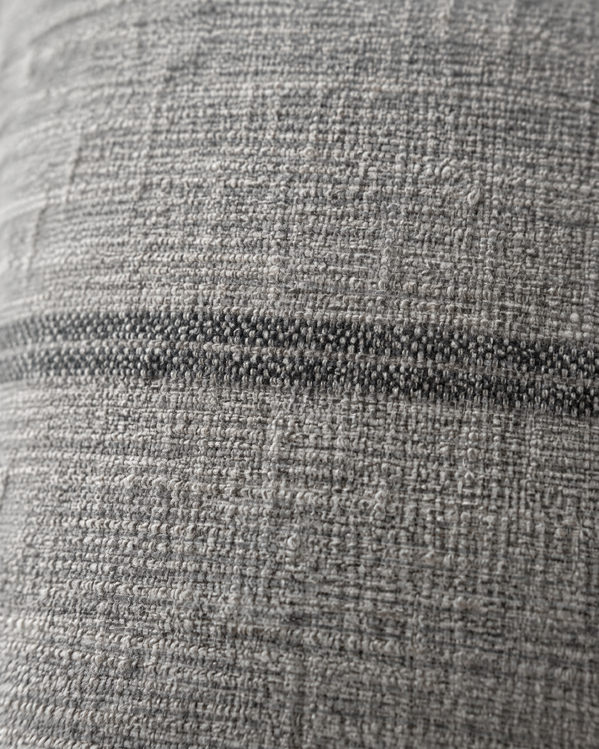 Macro close-up of a charcoal woven stripe on soft heathered grey hemp-cotton