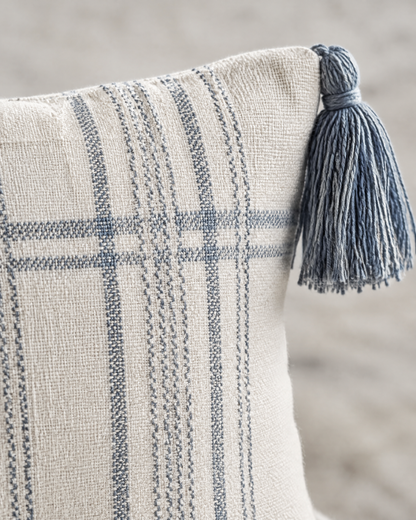 Macro close-up of fine slate-blue check lines on ivory with a blue corner tassel
